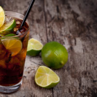 Cuba Libre Drink with lime on a wooden table